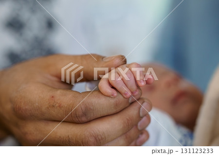 Tender Newborn Hand Holding Father's Finger, Close-up, Soft Focus, Emotional Connection, Pale Skin Tones, Warm Intimacy, Healthcare Concept, Portrait. 131123233