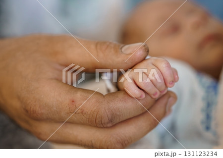 Newborn Baby Hand Holding Father's Finger. Intimate Connection, Tender Love, Soft Focus, Warm Colors, Parent-Child Relationship, First Touch. 131123234