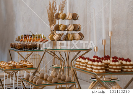 Luxurious Dessert Table Spread with Macarons, Fruit, and Pastries for Elegant Event or Wedding Gold Decor 131123259
