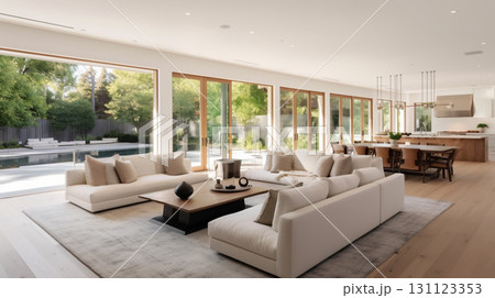 A modern, open-concept living room and kitchen with large windows overlooking a pool and garden, featuring white sofas, a wooden coffee table, and a dining area.  131123353