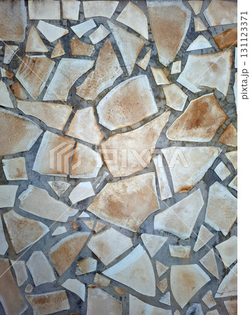 This wall showcases a beautiful natural stone finish with varied textures and colors. The arrangement of stones creates an eye-catching design that adds character. 131123371