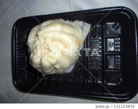 A Freshly Steamed Bun Resting in a Black Plastic Tray on a White Surface A Freshly Steamed Bun Resting in a Black Plastic Tray on a White Surface 131123658