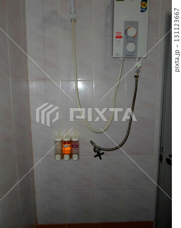 A Shower Setup with a Water Heater and Wall Mounted Soap Dispensers in a Tiled Bathroom A Shower Setup with a Water Heater and Wall Mounted Soap Dispensers in a Tiled Bathroom 131123667