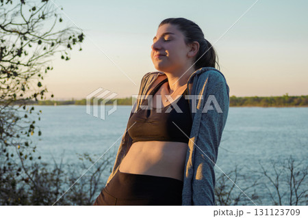Caucasian girl relaxing in nature at sunset hour,balance, harmony and well-being 131123709