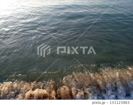 A Closeup of Gentle Ocean Waves Lapping at the Shore with a Soft Evening Glow A Closeup of Gentle Ocean Waves Lapping at the Shore with a Soft Evening Glow 131123863