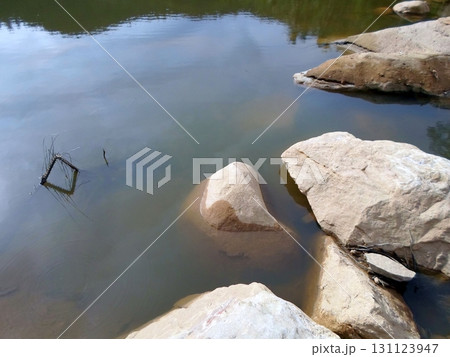 Calm Lake Edge with Smooth Boulders and a Submerged Frame in Clear Water Calm Lake Edge with Smooth Boulders and a Submerged Frame in Clear Water 131123947