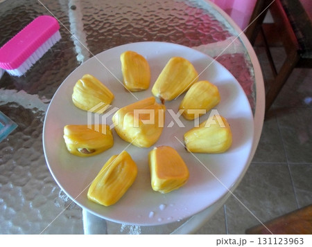 Sliced Jackfruit Pieces Arranged on a Plate on a Glass Table with a Brush Nearby Sliced Jackfruit Pieces Arranged on a Plate on a Glass Table with a Brush Nearby 131123963