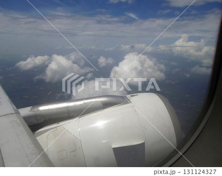 A Stunning View of Fluffy Clouds and the Airplane Engine Through a Passenger Window A Stunning View of Fluffy Clouds and the Airplane Engine Through a Passenger Window 131124327