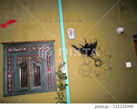 Courtyard Wall Decorated with a Painted Cabinet and Abstract Art Pieces Courtyard Wall Decorated with a Painted Cabinet and Abstract Art Pieces 131124360