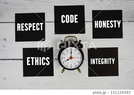 Ethics, Respect, Code, Honesty, Integrity text written on sticky note and alarm clock flat lay on wooden background 131124393