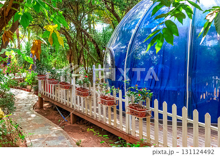 A blue dome-shaped house surrounded by green trees and a white fence. Sanya, China. A blue dome-shaped house surrounded by green trees and a white fence. Sanya, China. 131124492