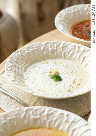 Assorted gourmet soups served in elegant ceramic bowls 131124733