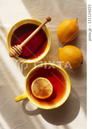 Flat Lay with Lemon Tea and Honey on Light Table under Sun Light Flat Lay with Lemon Tea and Honey on Light Table under Sun Light 131124855