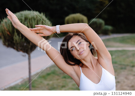 Young woman practicing yoga stretching in a park Young woman practicing yoga stretching in a park 131124940
