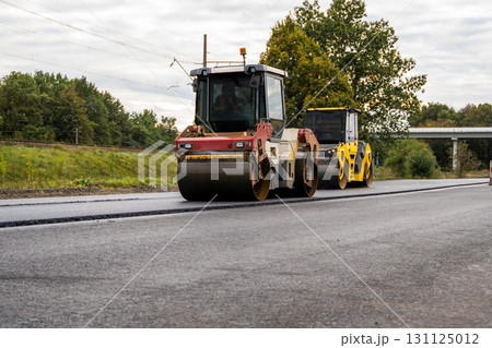 Road roller and asphalt paver working together at road construction site Road roller and asphalt paver working together at road construction site 131125012