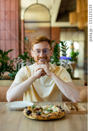 Ginger bearded man in glasses enjoying pizza while cafe 131125135