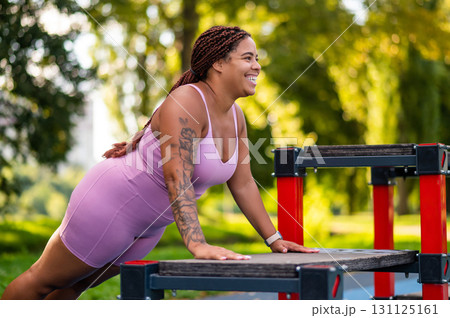 Female athlete training push ups on sports ground 131125161