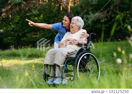 Home nurse taking care of elderly woman in wheelchair. 131125250