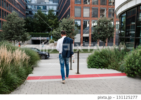 Businessman walking down the street heading to office building. 131125277