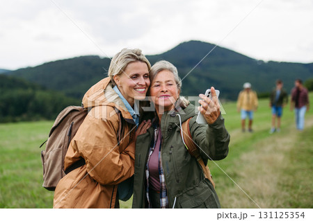 Mature daughter and her mom on hiking trip in nature. 131125354