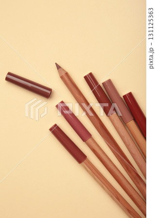Different lip pencils on beige background. Cosmetic product. Vertical photo Different lip pencils on beige background. Cosmetic product. Vertical photo 131125363