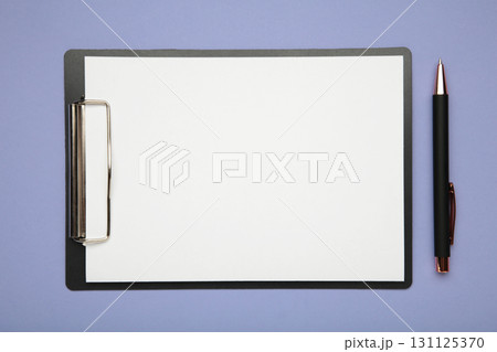 Pen and black clipboard with paper on purple background. Pen and black clipboard with paper on purple background. 131125370