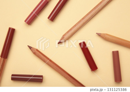 Different lip pencils on beige background. Cosmetic product Different lip pencils on beige background. Cosmetic product 131125386