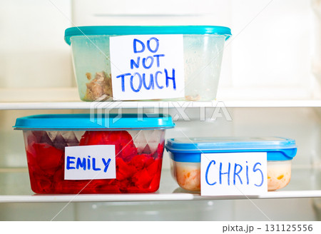 Do Not Touch sticker on lunch boxes in office refrigerator. Angry and hungry workers concept. 131125556