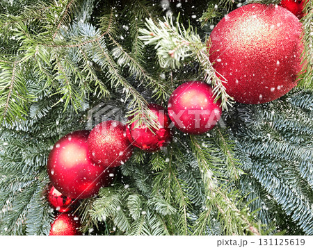 Christmas tree with red baubles and lights garland. Urban city decoration at street. Xmas holiday pattern. Cold winter weather. Outdoors. 131125619