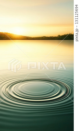 Serene water ripples radiating outward in soft patterns at sunset, creating tranquil atmosphere. gentle waves reflect warm colors of sky 131125694