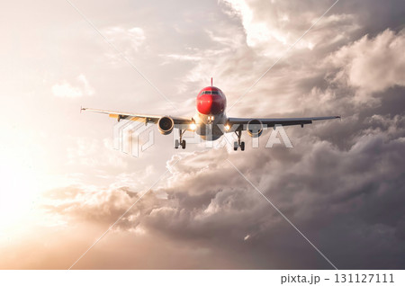 Passenger airplane flying towards the setting sun above the clouds 131127111
