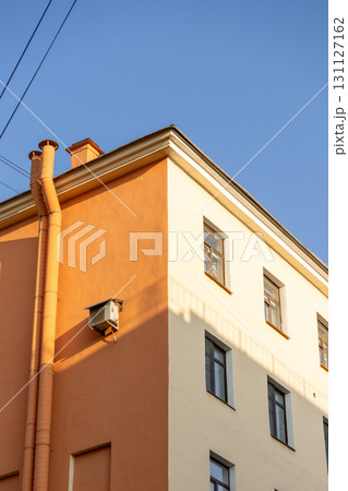 Air conditioners on the facade of a yellow house against a blue sky. An air ventilation. Air conditioners on the facade of a yellow house against a blue sky. An air ventilation. 131127162