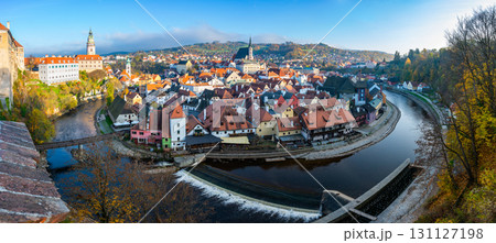 Panoramic view of Cesky Krumlov, showcasing the UNESCO-listed historic center surrounded by the Vltava River in a meander. A sunny autumn day highlights the town's charm. Panoramic view of Cesky Krumlov, showcasing the UNESCO-listed historic center surrounded by the Vltava River in a meander. A sunny autumn day highlights the town's charm. 131127198