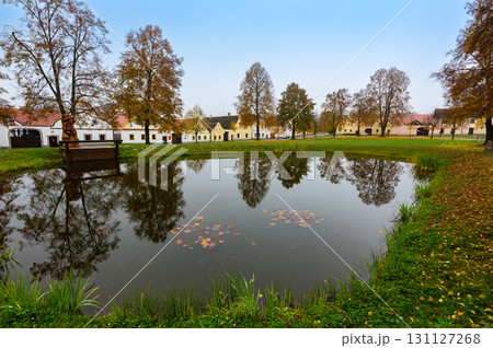 Medieval houses, farms, and granaries of Holasovice village in South Bohemia, arranged around a park with ponds. A UNESCO World Heritage Site showcasing rural baroque architecture Medieval houses, farms, and granaries of Holasovice village in South Bohemia, arranged around a park with ponds. A UNESCO World Heritage Site showcasing rural baroque architecture 131127268