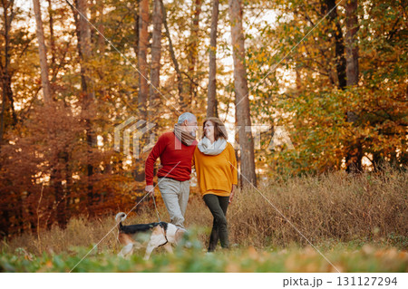 Senior couple walking dog in autumn forest. Senior couple walking dog in autumn forest. 131127294
