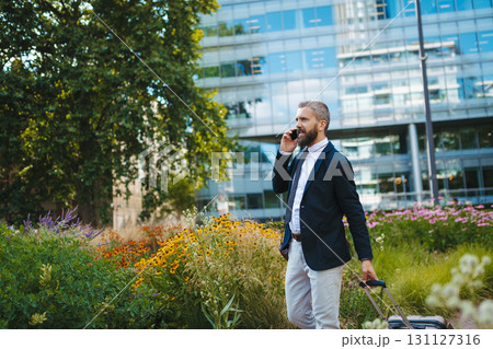Handsome businessman with smartphone in the city, making a phone call. 131127316