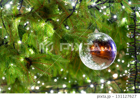 A beautiful glass ornament hanging on a Christmas tree, reflecting the lively atmosphere of the square in Pilsen, capturing the essence of the holiday spirit A beautiful glass ornament hanging on a Christmas tree, reflecting the lively atmosphere of the square in Pilsen, capturing the essence of the holiday spirit 131127627