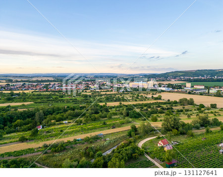 A stunning drone view of Hrusovany u Brna, showcasing the charming town, surrounding vineyards, and a distant, scenic view of the Palava Hills. 131127641