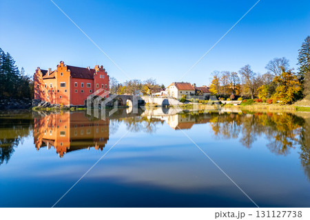 A panoramic drone photo of Cervena Lhota Castle (Red Chateau, Schloss Rot), showing the castle reflection in the pond below.  131127738