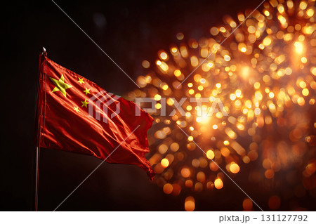 The night sky is illuminated by bright fireworks and the Chinese flag in the foreground. 131127792