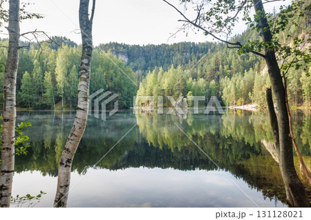 The Piskovna lake in Adrspach-Teplice Rocks area, in Hradec Kralove Region in the Czech Republic, Europe. A serene lake surrounded by lush green forest, creating a calming and reflective atmosphere. The Piskovna lake in Adrspach-Teplice Rocks area, in Hradec Kralove Region in the Czech Republic, Europe. A serene lake surrounded by lush green forest, creating a calming and reflective atmosphere. 131128021