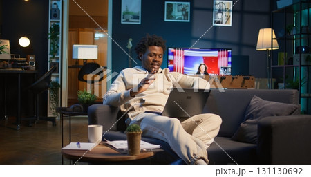 Male remote worker smiling during a virtual meeting with his trainer, showcasing effectiveness of online tools and internet connection. Person starting training session for the new job. Camera B. Male remote worker smiling during a virtual meeting with his trainer, showcasing effectiveness of online tools and internet connection. Person starting training session for the new job. Camera B. 131130692