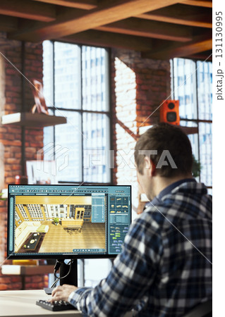 Interior designer uses architectural software on computer to help customers with remodeling job commission. Freelancer in home office preparing visual preview for clients on PC 131130995