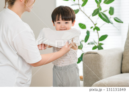 自宅のリビングで息子の着替えを手伝う母親 131131849