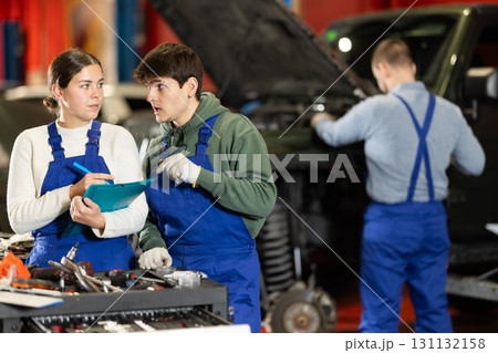 Woman discussing car repair plan with mechanic Woman discussing car repair plan with mechanic 131132158