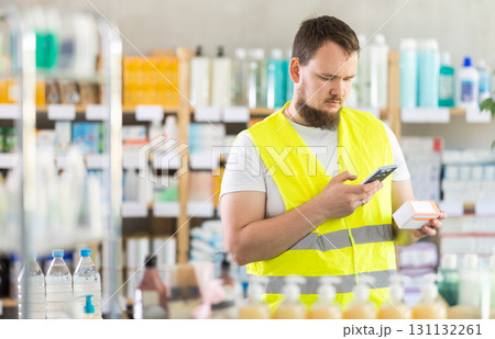 Male builder scans code on package of pills to check expiration date Male builder scans code on package of pills to check expiration date 131132261