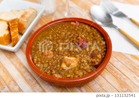 Stewed lentils with chorizo and vegetables in earthenware bowl Stewed lentils with chorizo and vegetables in earthenware bowl 131132541
