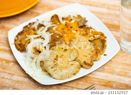 Salted white milk mushrooms with onion rings on plate 131132557