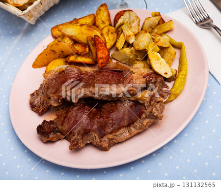 Tasty baked beef steak with potatoes and artichokes 131132565