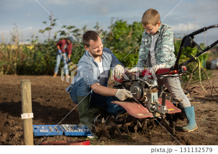Man and his son are repairing garden equipment 131132579